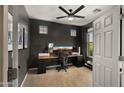 Office space with dark accent wall, multiple monitors, neutral carpet, and natural light at 10224 E Talameer Ave, Mesa, AZ 85212