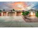 Inviting single-story home featuring a three-car garage and desert landscaping at sunset at 13204 W Palo Verde Dr, Litchfield Park, AZ 85340