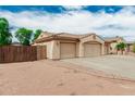 Side view of a home with a three-car garage and desert landscaping at 13204 W Palo Verde Dr, Litchfield Park, AZ 85340