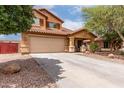 Charming two-story home featuring desert landscaping, a long driveway, and a cozy covered porch entry at 136 W Brahman Blvd, San Tan Valley, AZ 85143