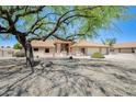 Charming home exterior with desert landscaping, a tree, tile roof, and a two-car garage at 13650 N 70Th Dr, Peoria, AZ 85381