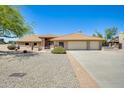 Exterior of a well-kept home featuring desert landscaping, a tile roof, and a two-car garage at 13650 N 70Th Dr, Peoria, AZ 85381