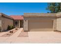 Beige home featuring a red tile roof, a front entrance gate, desert landscaping and an attached beige garage at 1506 N Oak St, Tempe, AZ 85288