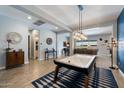 Open-concept living area features a game table, stylish lighting, and seamless flow to other spaces at 16226 S 35Th Dr, Phoenix, AZ 85045