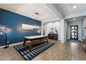 Stylish living room with blue accent wall, game table, elegant lighting, and hardwood flooring at 16226 S 35Th Dr, Phoenix, AZ 85045