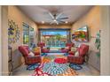 Comfortable patio featuring cushioned chairs, barrel tables, a colorful rug and a ceiling fan for optimal relaxation by the pool at 19877 S 185Th Way, Queen Creek, AZ 85142