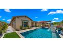 Exterior view showing the pool, patio, and manicured landscaping that enhances the appeal of this charming, single-story home at 19877 S 185Th Way, Queen Creek, AZ 85142