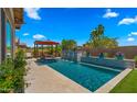 Lovely backyard pool area showcasing a pergola, water feature, and lush landscaping, perfect for outdoor enjoyment at 19877 S 185Th Way, Queen Creek, AZ 85142