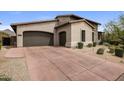 Spacious driveway leading to a two-car garage, complemented by desert landscaping and tasteful exterior finishes at 20055 N 96Th Way, Scottsdale, AZ 85255