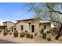 Inviting home with a stone and stucco exterior, lush desert landscaping, and a charming entryway at 20055 N 96Th Way, Scottsdale, AZ 85255