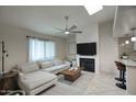 Bright living room with a fireplace, ceiling fan, and comfortable white sectional sofa at 2020 W Union Hills Dr # 110, Phoenix, AZ 85027