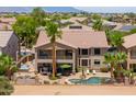 A resort-style backyard with a pool, spa, lounge area, outdoor kitchen and a covered patio at 21841 N Ingram Ct, Maricopa, AZ 85138
