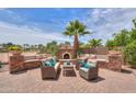 Outdoor living space with comfortable seating, a decorative stone fireplace, and a beautifully paved patio at 21841 N Ingram Ct, Maricopa, AZ 85138