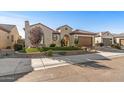 Charming single-story home showcasing professional desert landscaping with a clay tile roof and attached two-car garage at 25971 W Taro Dr, Buckeye, AZ 85396