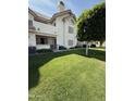 Multi-story apartment building featuring landscaped lawn and beautiful tree at 2801 N Litchfield Rd # 65, Goodyear, AZ 85395