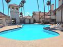 A beautifully maintained pool surrounded by lounge chairs and palm trees, perfect for relaxation at 2801 N Litchfield Rd # 65, Goodyear, AZ 85395
