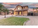 Beautifully landscaped home with well-manicured front lawn and inviting curb appeal at twilight at 2986 E Country Shadows St, Gilbert, AZ 85298