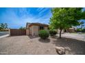 Side yard features decorative rock landscaping, greenery and secure fencing at 3103 S Benton --, Mesa, AZ 85212