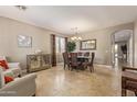 Spacious dining room showcasing neutral walls, travertine floors, and a elegant chandelier at 6847 S 27Th Pl, Phoenix, AZ 85042