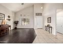 Bright living room with vaulted ceilings, a light color palette, and a harmonious blend of tile and hardwood floors at 6971 W El Cortez Pl, Peoria, AZ 85383