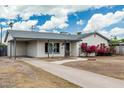 Charming single-story home with a carport, long driveway and xeriscaped front yard at 738 S Pomeroy --, Mesa, AZ 85210