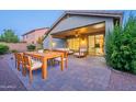 Relaxing covered patio featuring a dining table and comfortable seating with a view of the outdoor kitchen at 7606 E Globemallow Ln, Gold Canyon, AZ 85118