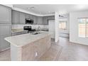 Spacious kitchen boasts granite countertops, gray cabinets, and modern appliances at 7767 W Sierra Vista Dr, Glendale, AZ 85303