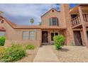 Inviting exterior view of a charming townhome showcasing a brick chimney and colorful landscaping at 8111 W Wacker Rd # 62, Peoria, AZ 85381