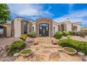 A charming home's front entrance features stone accents, a decorative front door, and patio seating at 8502 E Santa Catalina Dr, Scottsdale, AZ 85255