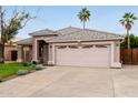 Inviting single-story home with desert landscaping, a two-car garage, and a comfortable front porch at 10280 N 94Th Dr, Peoria, AZ 85345