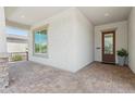 Covered front porch featuring brick flooring, stucco walls, and a stylish front door with glass accents at 11872 W Duane Ln, Peoria, AZ 85383