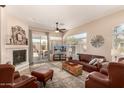 Spacious living room with fireplace, tile flooring, and access to outdoor patio through sliding glass doors at 14124 W Bent Tree S Cir, Litchfield Park, AZ 85340
