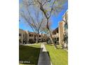 Condominium complex with manicured lawns and lush green landscaping throughout the community at 145 N 74Th St # 125, Mesa, AZ 85207