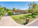 Beautiful single story home with a lush front lawn, mature shade trees, and a brick mailbox at 1562 W Las Palmaritas Dr, Phoenix, AZ 85021