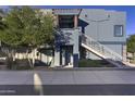 Inviting two-story home features a private entry with an exterior staircase, complemented by mature trees and desert landscaping at 16525 E Avenue Of The Fountain -- # 113, Fountain Hills, AZ 85268