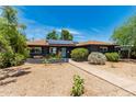 Home featuring a neat front yard, solar panels, and a walkway to the front door at 1814 W Thomas Rd, Phoenix, AZ 85015
