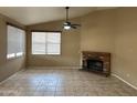 Spacious living room with a fireplace, neutral walls, tile flooring, and bright window at 18899 N 77Th Ave, Glendale, AZ 85308