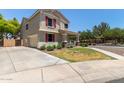 Exterior shot showing charming two-story home with a spacious front yard and driveway at 2150 E Sunland Ave, Phoenix, AZ 85040