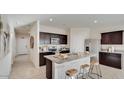 Modern kitchen with granite countertops, dark wood cabinetry, and stainless steel appliances at 24052 W Pima St, Buckeye, AZ 85326
