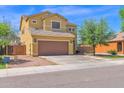 Two-story home with a brown garage door, complemented by desert landscaping and a tree in the front yard at 2519 W Burgess Ln, Phoenix, AZ 85041