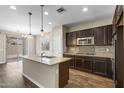 Modern kitchen featuring granite countertops, dark cabinetry, stainless steel appliances, and pendant lighting at 322 N 78Th Pl, Mesa, AZ 85207