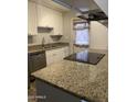 A kitchen features stainless steel dishwasher, granite countertop, and neutral colored walls at 3229 W Cholla St, Phoenix, AZ 85029