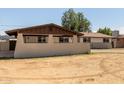 A neutral colored single-story home featuring a spacious front yard and a covered porch at 3719 W Griswold Rd, Phoenix, AZ 85051