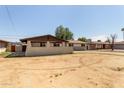 A neutral colored single-story home featuring a spacious front yard and a covered porch at 3719 W Griswold Rd, Phoenix, AZ 85051