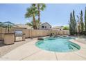 Private backyard pool with rock waterfall feature, barbecue island, and lush palm tree landscaping at 4353 W Walton Way, Chandler, AZ 85226