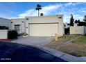 Neutral-colored home featuring a two-car garage, desert landscaping, and paved driveway at 4727 E Euclid Ave, Phoenix, AZ 85044