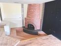 Cozy living room featuring a brick fireplace and tiled flooring for a unique and inviting atmosphere at 4727 E Euclid Ave, Phoenix, AZ 85044