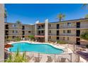 Bright and inviting pool area surrounded by palm trees, lounge chairs, and well-maintained landscaping at 4727 E Lafayette Blvd # 211, Phoenix, AZ 85018