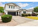 Charming two-story home featuring a black garage door and manicured landscaping at 512 E Bamboo Ln, San Tan Valley, AZ 85140