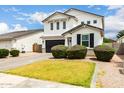 Stylish two-story home showcasing a paved driveway and lush green lawn at 512 E Bamboo Ln, San Tan Valley, AZ 85140